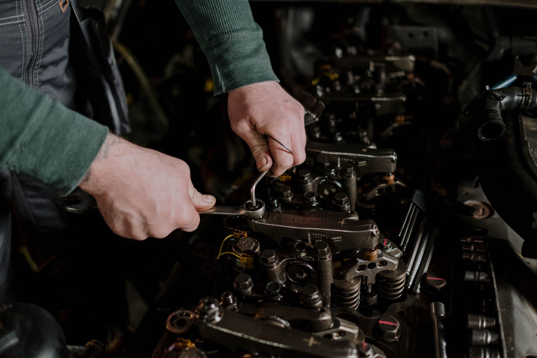 Mains d'un mécanicien qui travaillent sur un moteur avec un outil
