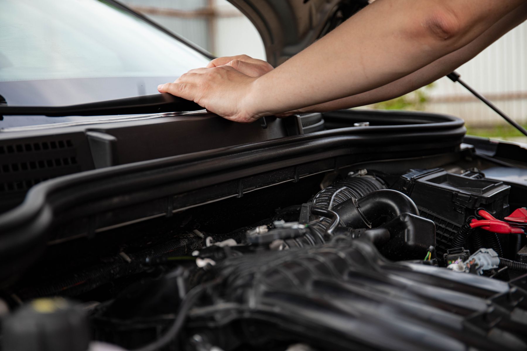 Mains d'un mécanicien dans le compartiment moteur d'une voiture